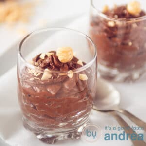 Two glasses with chocolate mousse topped with hazelnuts, square