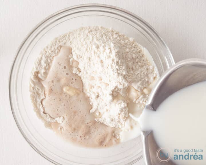 Pour milk into the flour and yeast mixture.