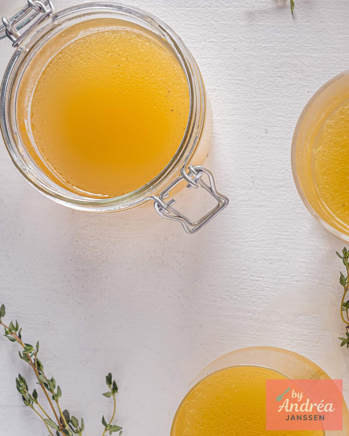 A top down picture of jars filled with chicken stock made from scratch.