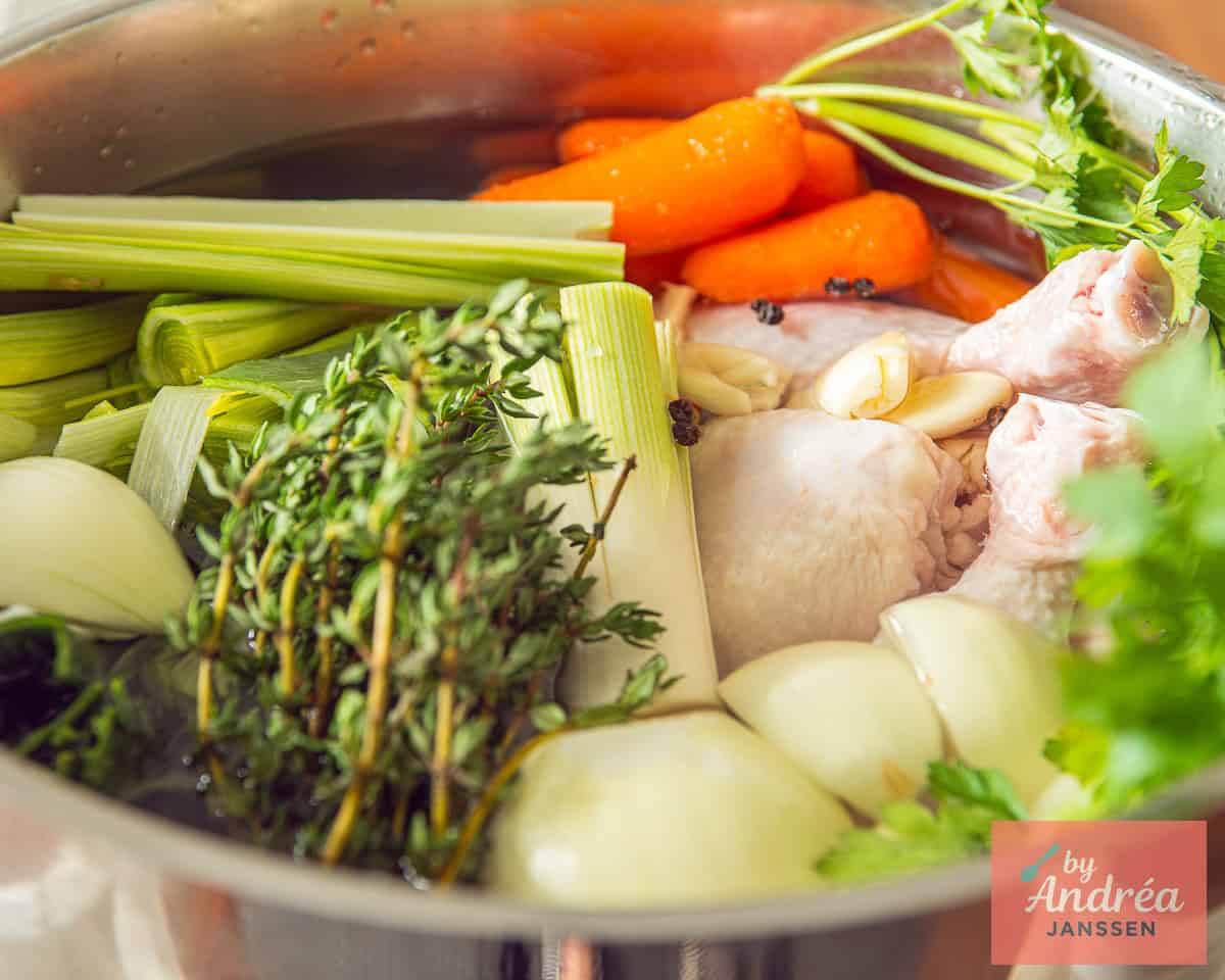 A pot with chicken, veggies and herbs