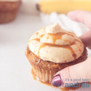 A square photo with a cupcake with caramel cream and caramel sauce. A hand takes the cupcake