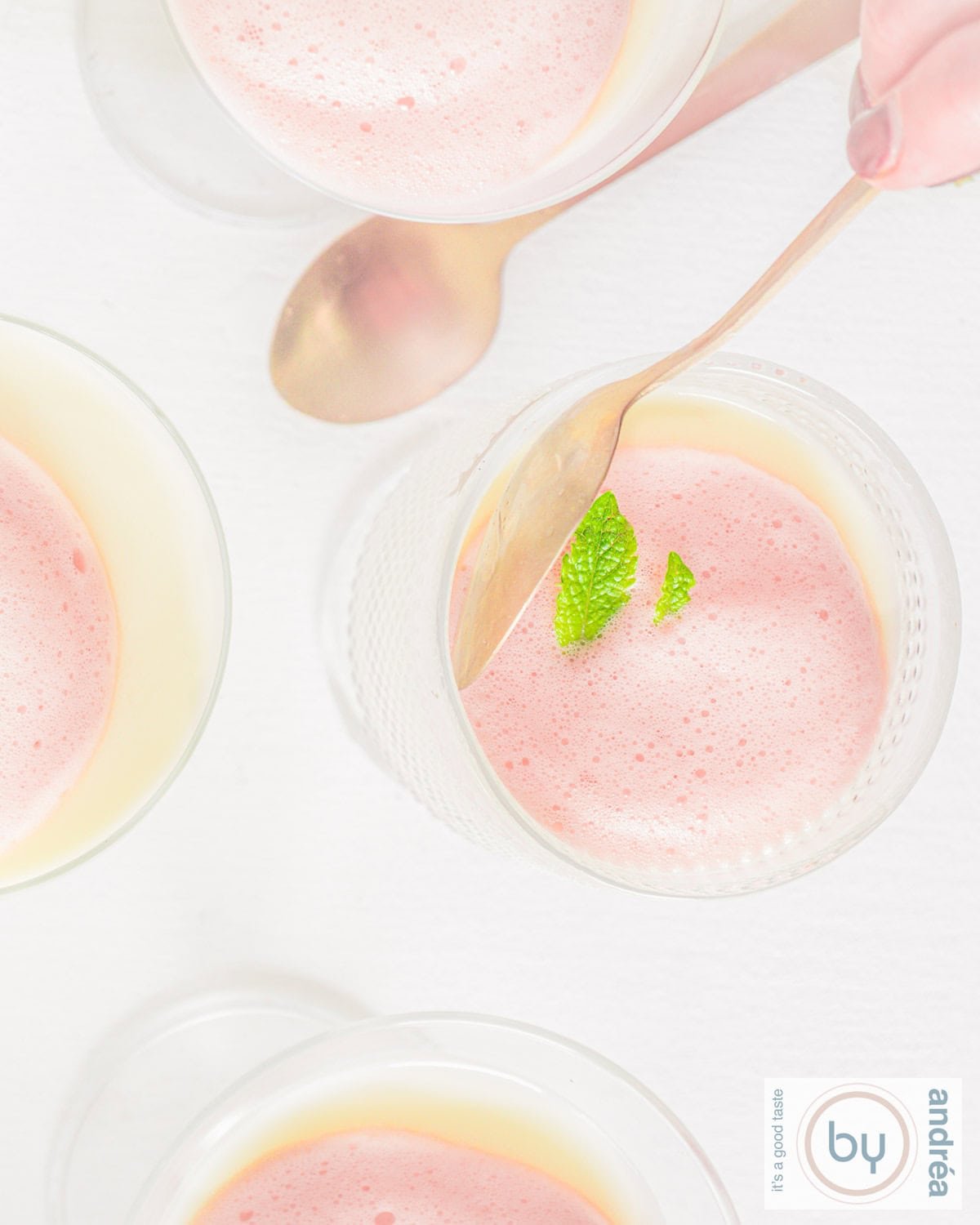 A top-down photo of glasses of buttermilk panna cotta with berry foam.