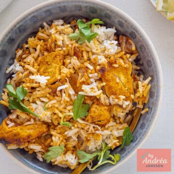 A square picture with a grey bowl filled with Indian Chicken Biryani