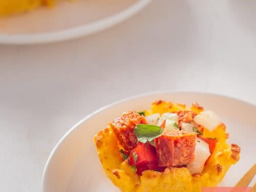 A square picture with a polenta cup filled with tomatoes.