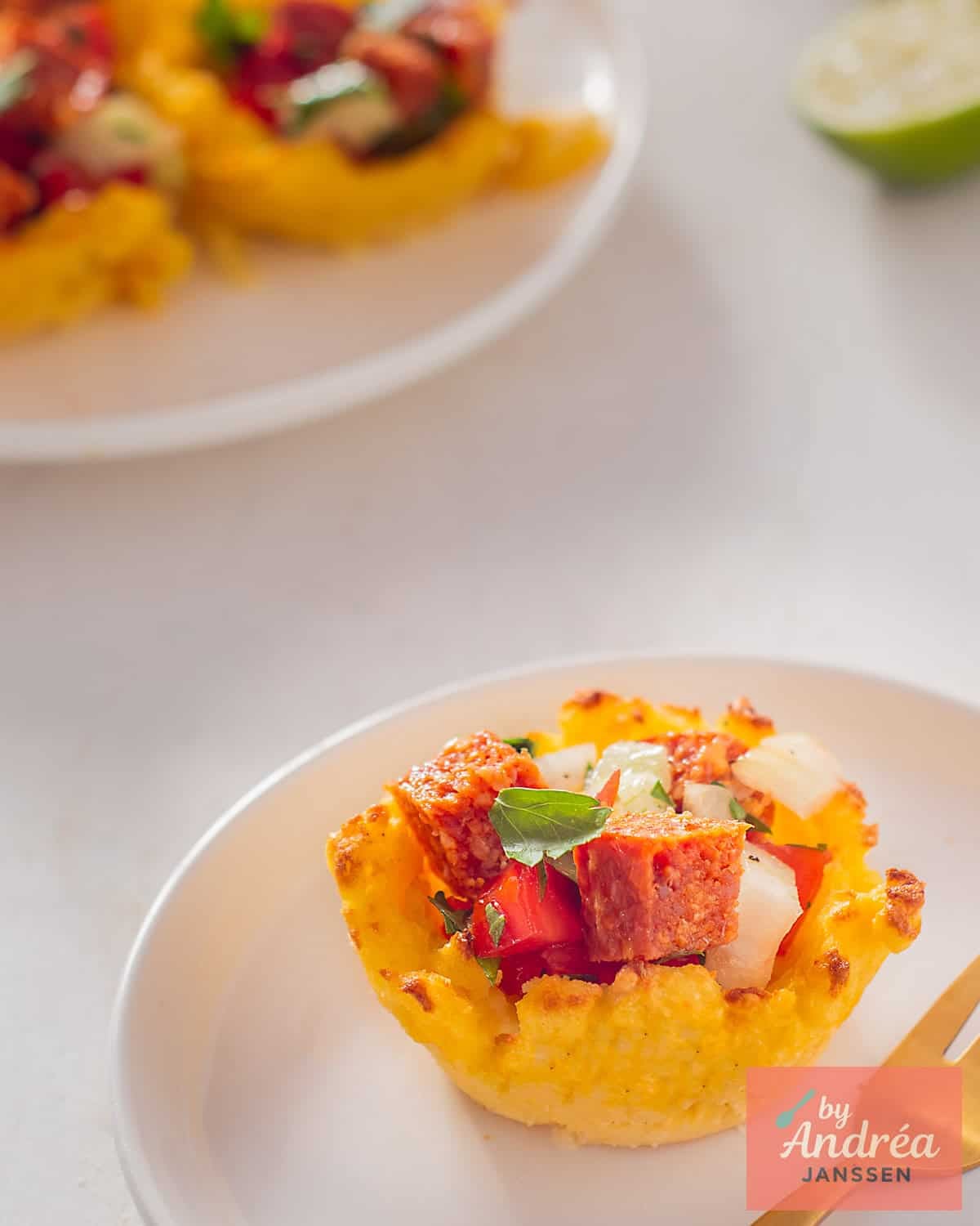 A polenta cup in the front with tomato, onion and parsley filling. Some more in the background.