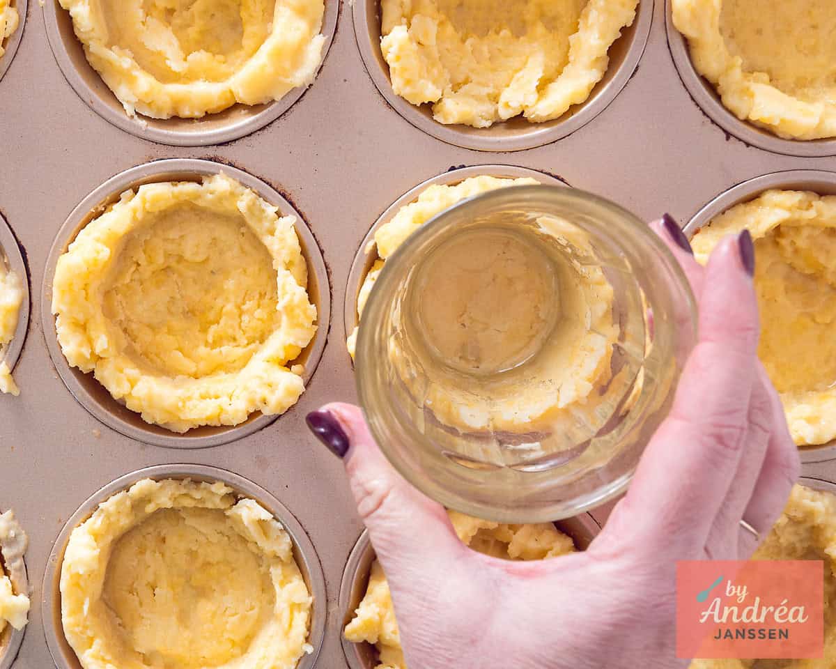 Polenta cups preparation with a glass to make holes.