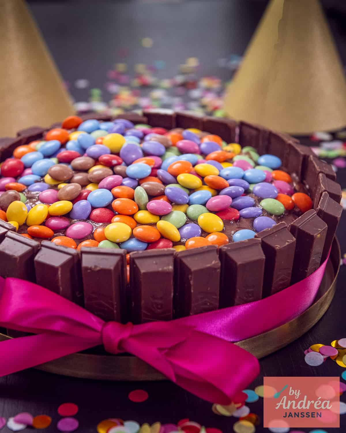 Vooraanzicht van een Kitkat taart met een roze strik eromheen.