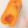 Half a roasted butternut squash is scraped out.