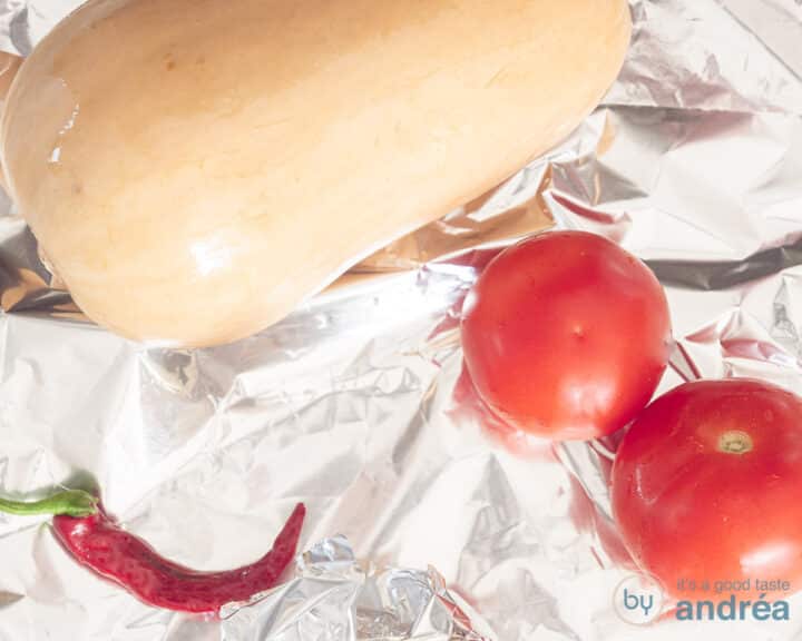Pumpkin, pepper and tomatoes lie on aluminum foil