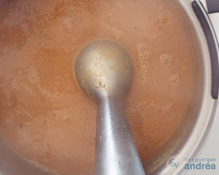 The pumpkin soup is pureed with a hand blender.