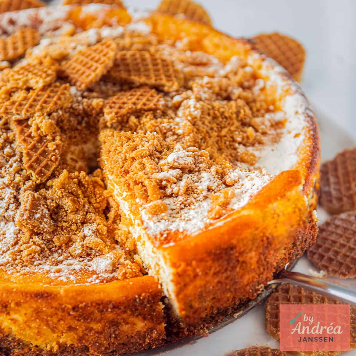 A square photo showing a slice of a stroopwafel cheesecake.