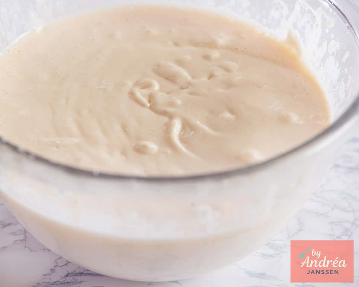 Een glazen schaal met cheesecake beslag