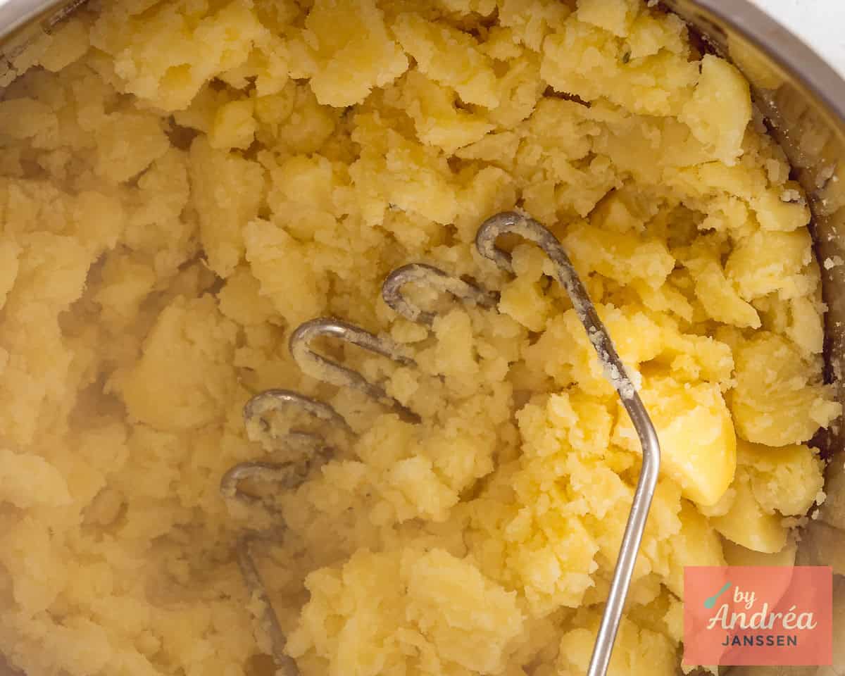 Fijnstampen van de aardappelen met een pureestamper