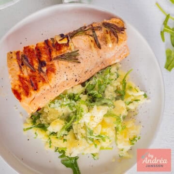 A square photo of mashed potatoes with arugula and grilled salmon