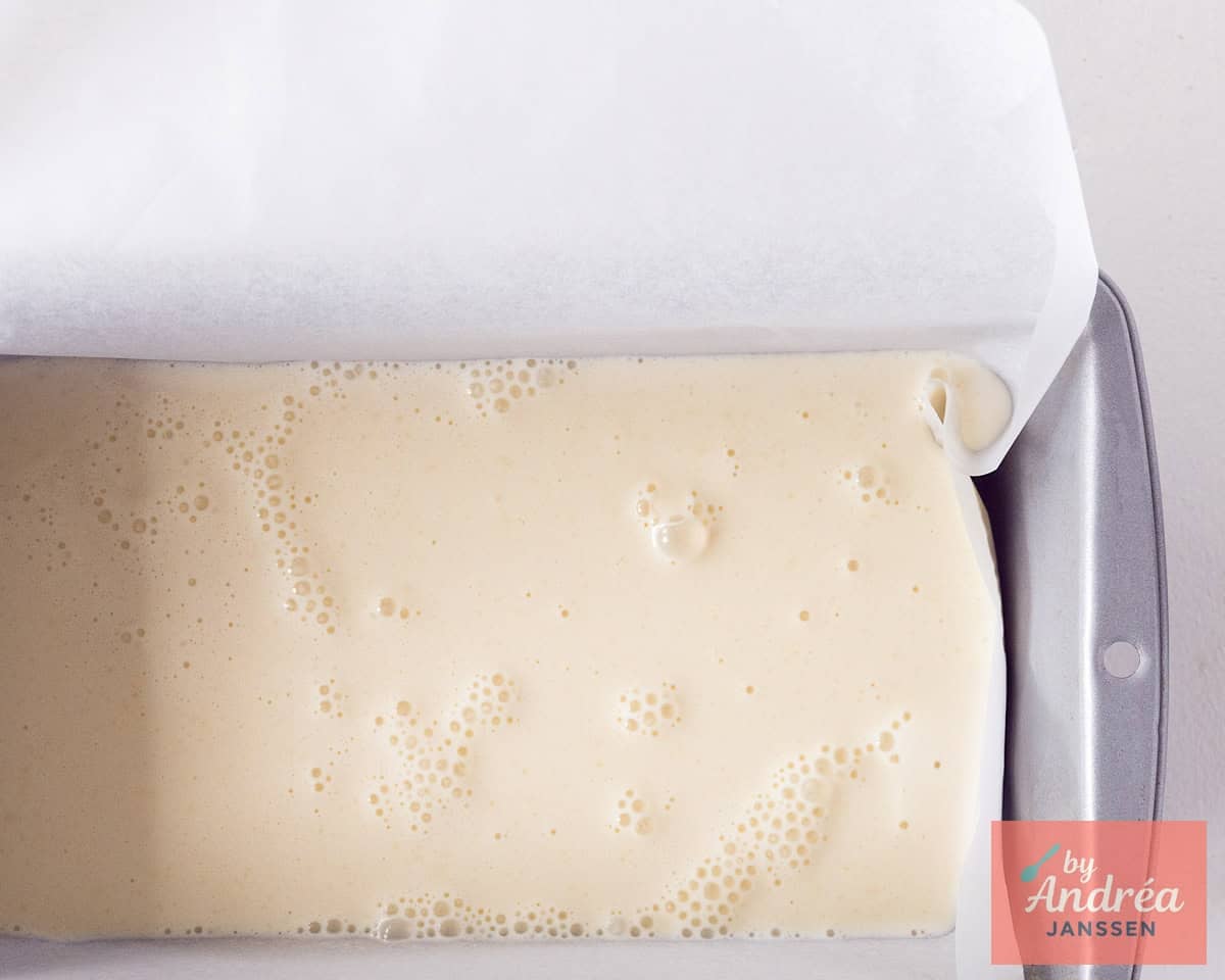 A cake tin filled with white ice cream base.