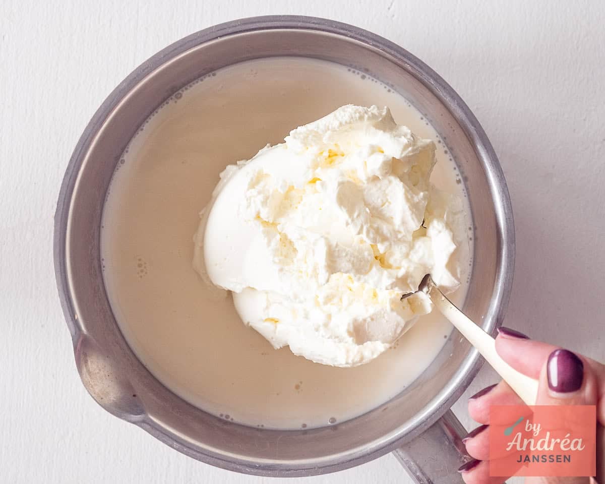 Mascarpone added to a pan with milk.