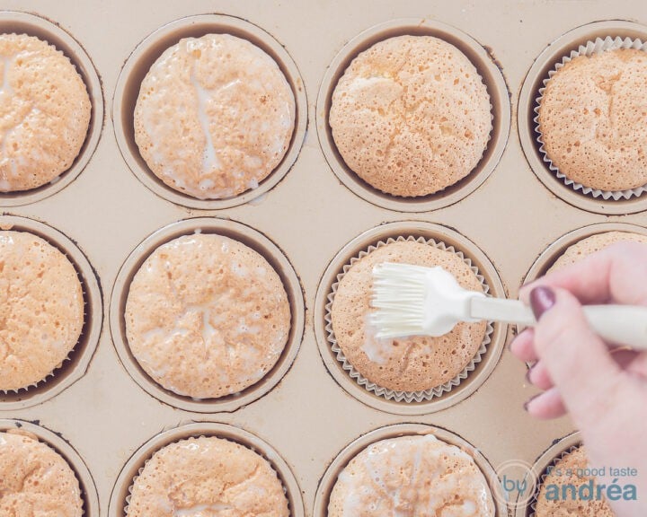 A cupcake mold with cupcakes, which are covered with condensed milk.