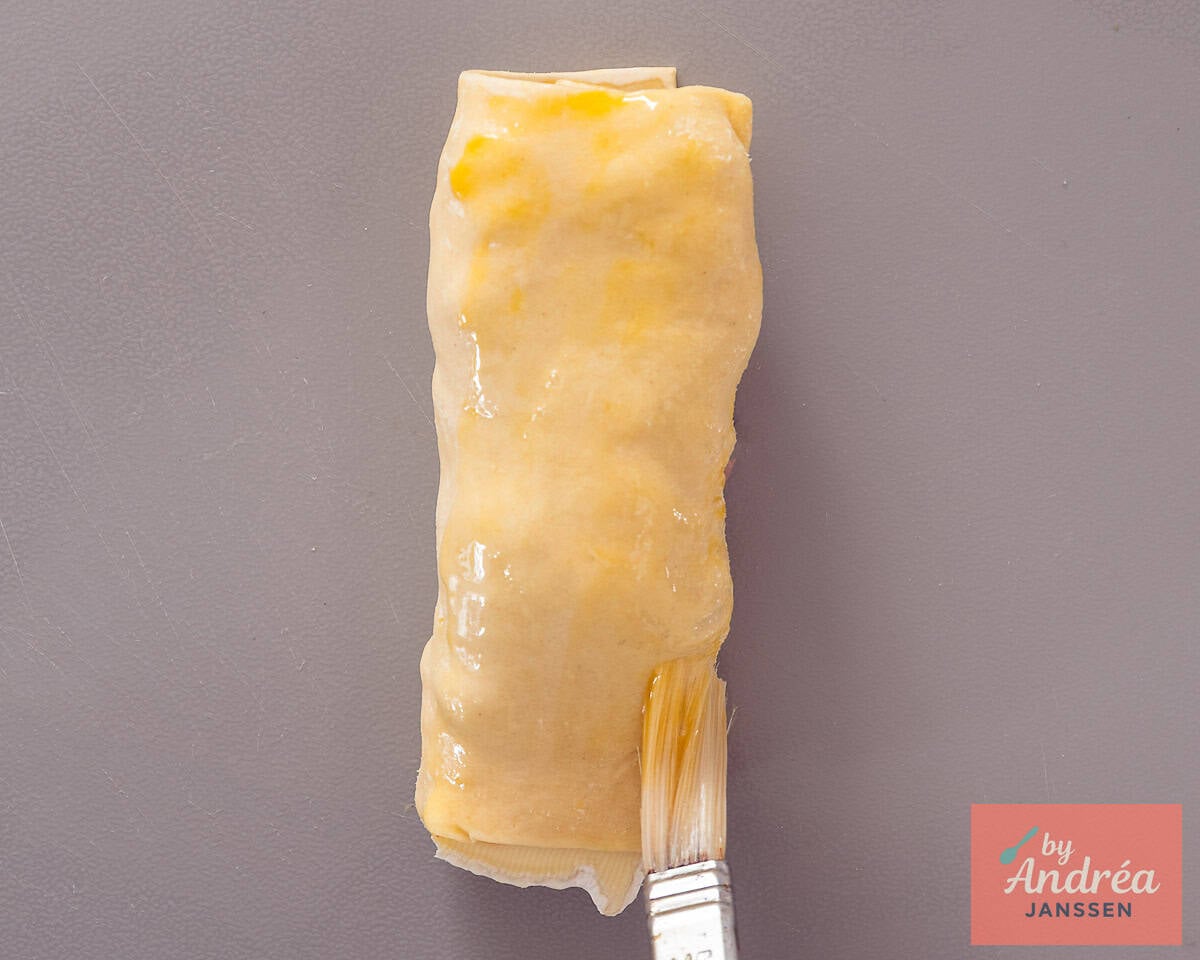 Brushing the puff pastry roll with beaten egg