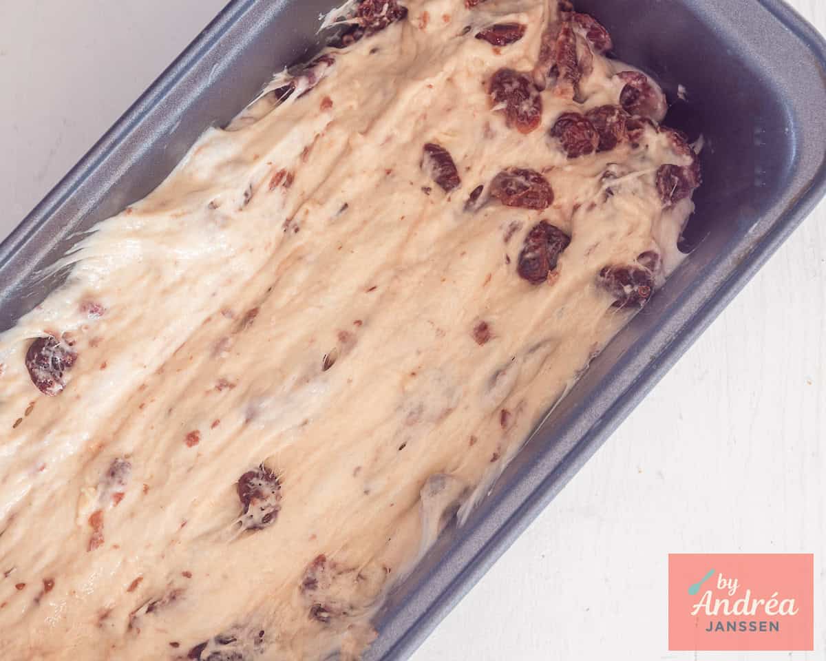 Cranberry loaf dough in a bread baking tin.