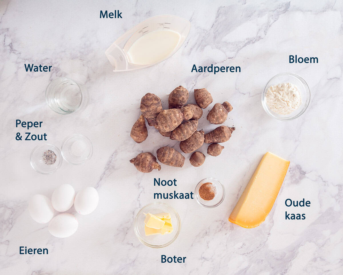 Ingredienten Aardpeer soufflé maken op een marmer witte ondergrond met tekstbeschrijving