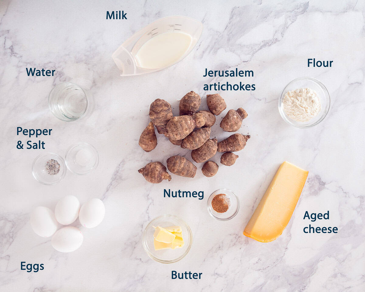 Ingredients Jerusalem Artichoke Soufflé with a white marble background and text description.