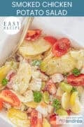 A photo from above of a bowl of potato salad, with vegetables and a delicious dressing. A text: easy recipe, smoked chicken potato salad