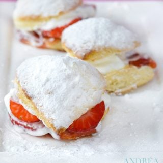 3 homemade scones with strawberries on a white plate