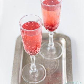 2 glasses Valentine's cocktail with strawberries on a serving plate