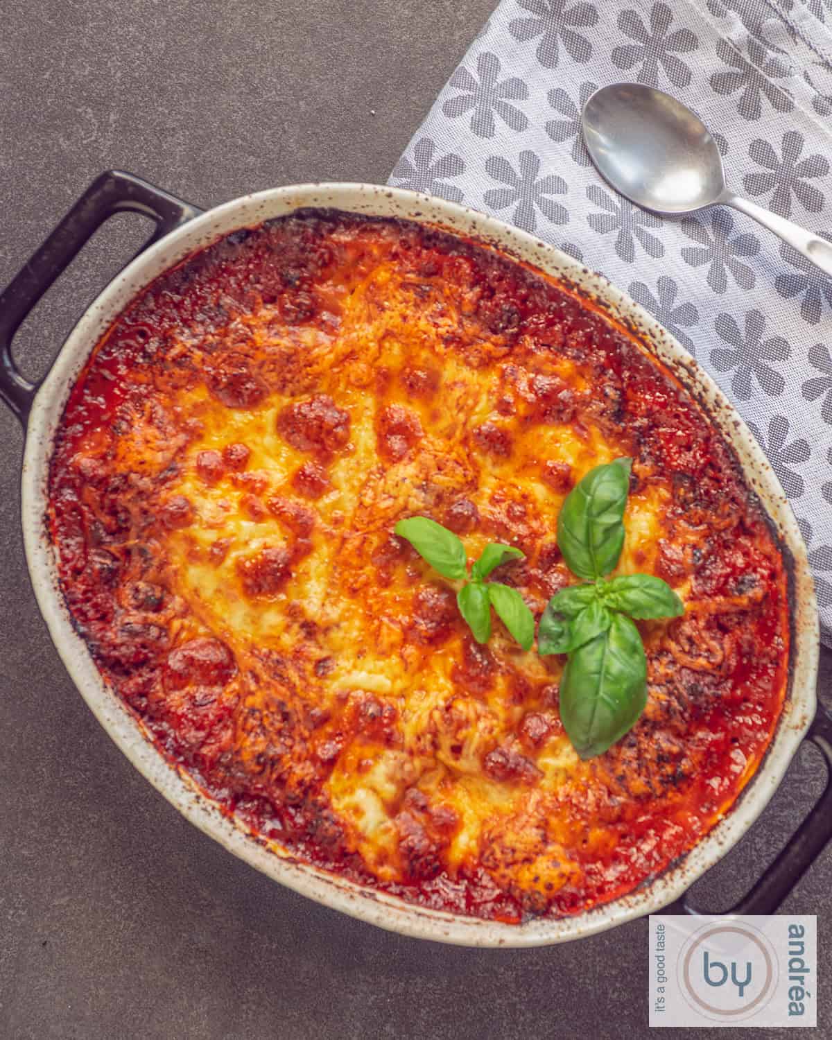 A top down picture of a black casserole dish filled with homemade lasagna