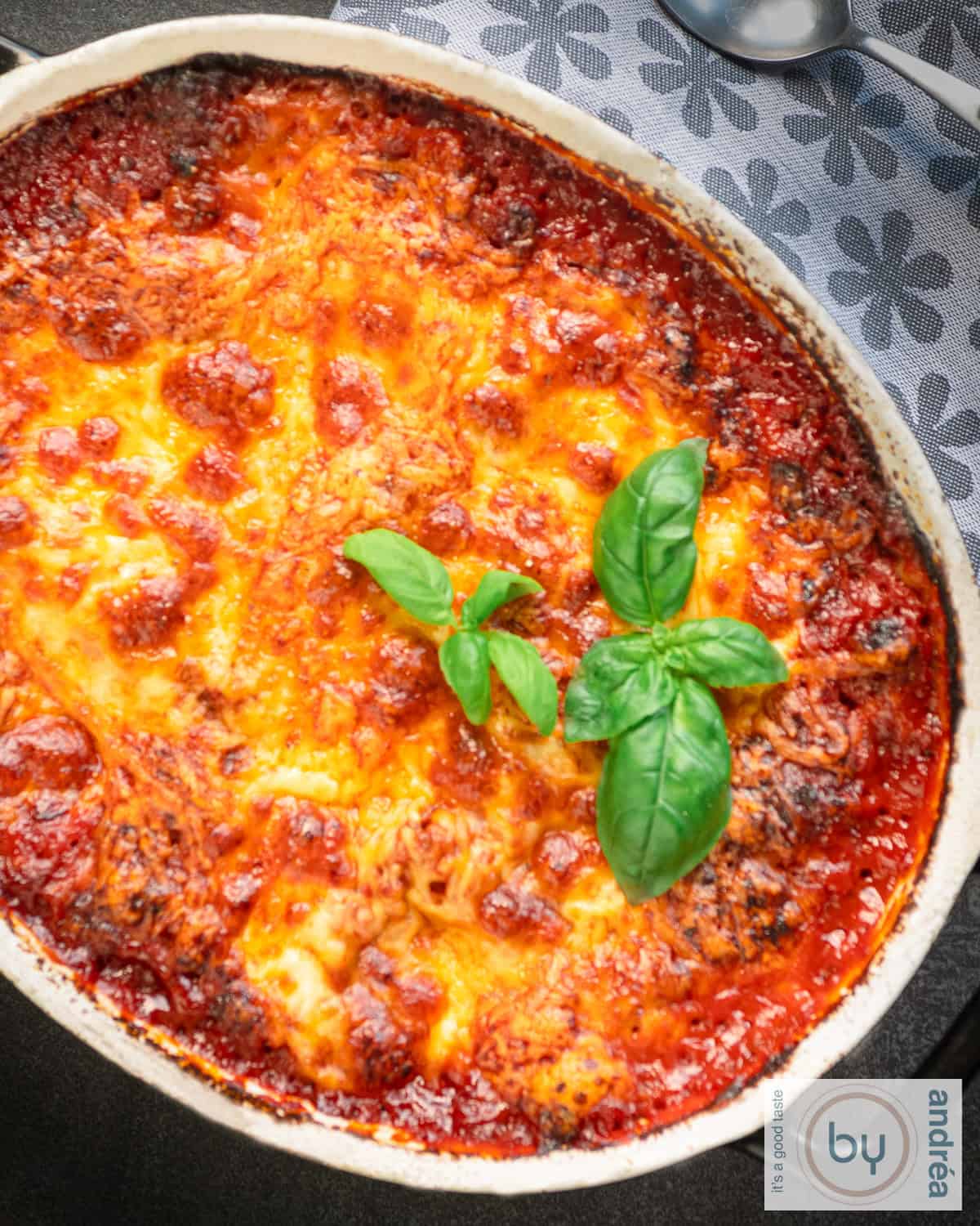 Part of a casserole dish with lasagne with a ground beef sauce and cheeses.