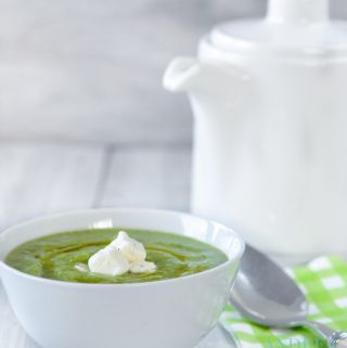 Broccoli soup in a white bowl and a tea pot