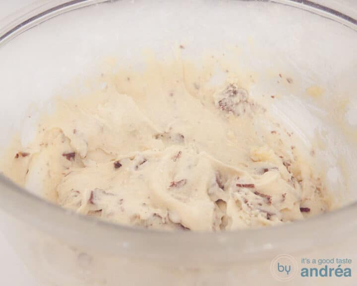 A glass bowl with cupcake batter with chocolate chips