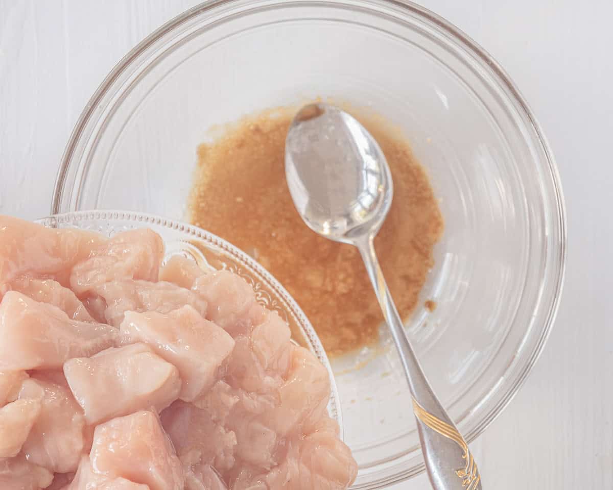 A glass bowl filled with marinate. Chicken is going to be add.