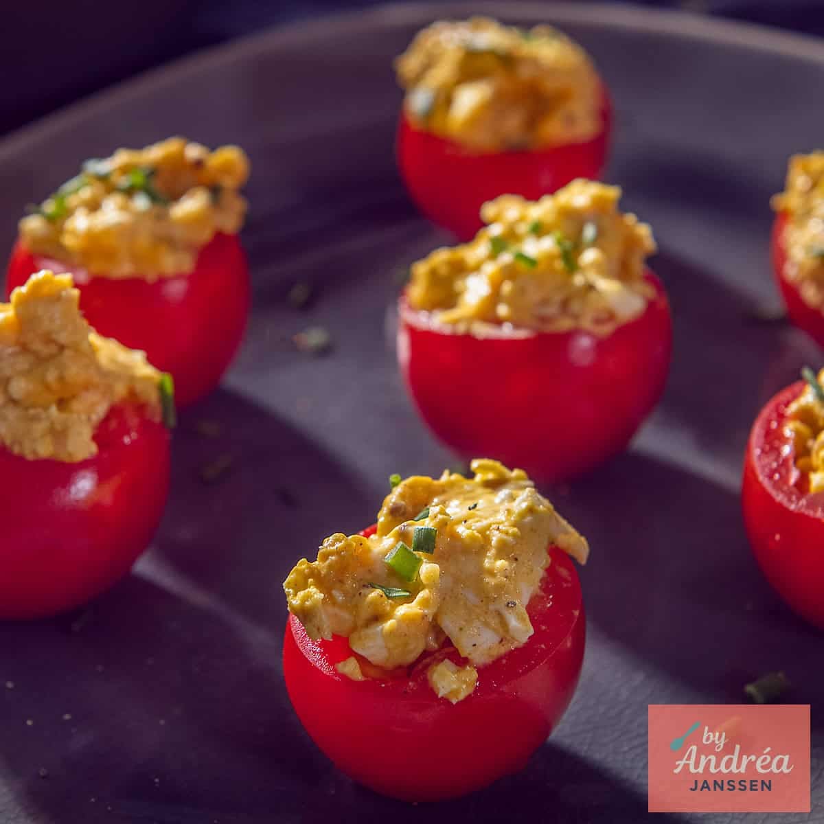 A square photo of several tomatoes with homemade egg salad