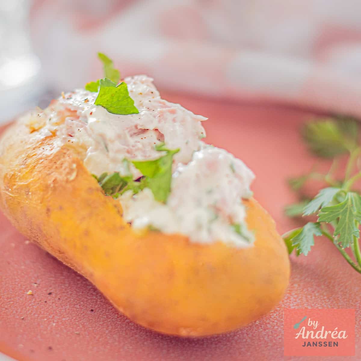 A square photo with a baked potato with quark and ham