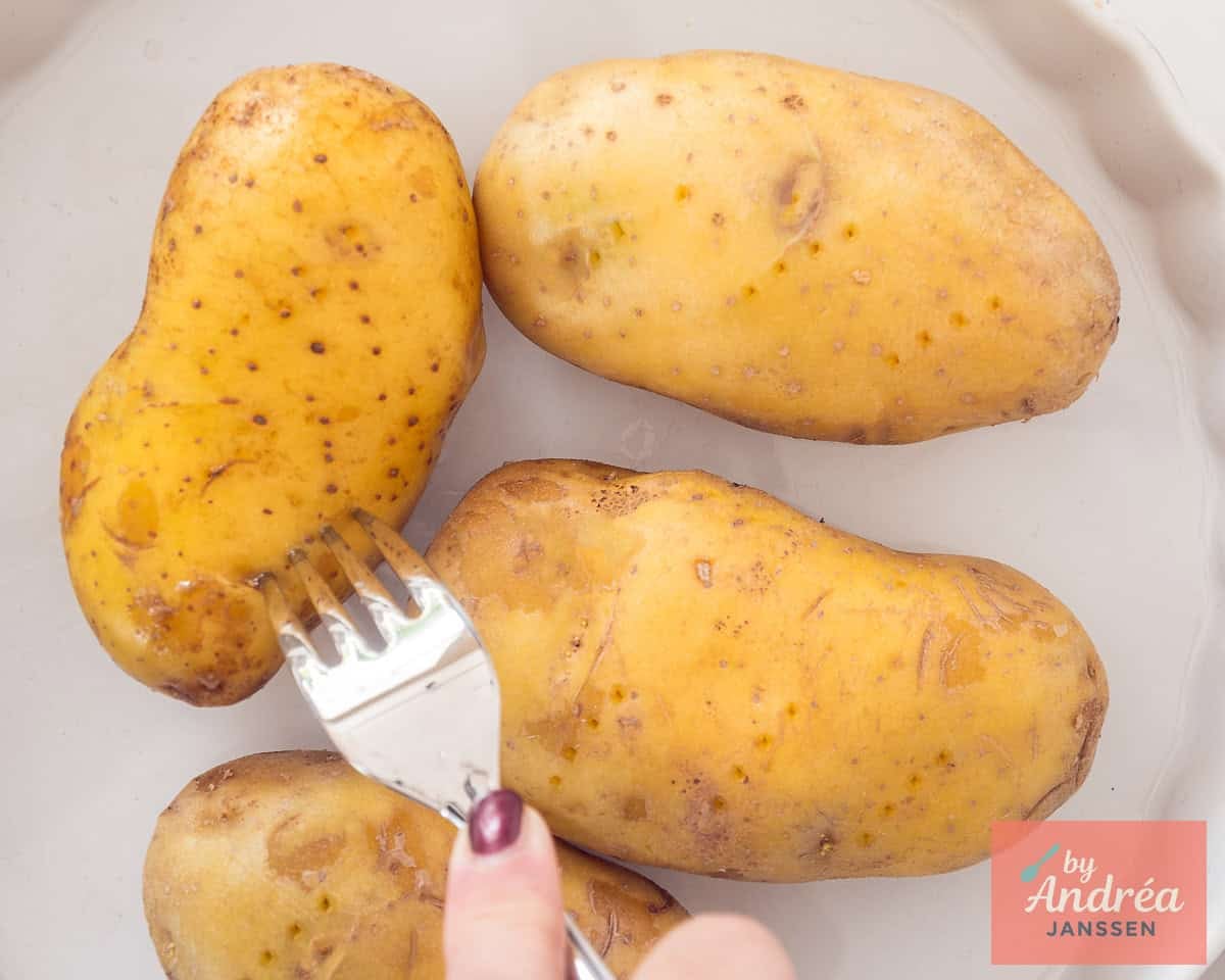 Met een vork wordt in de aardappels geprikt