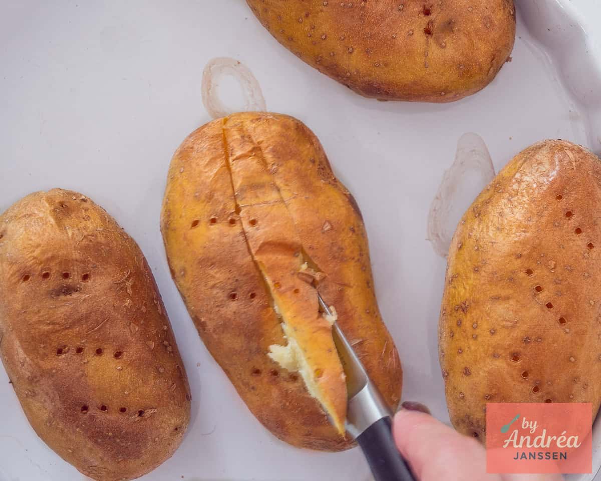 Een inkeping in de gepofte aardappel wordt gemaakt