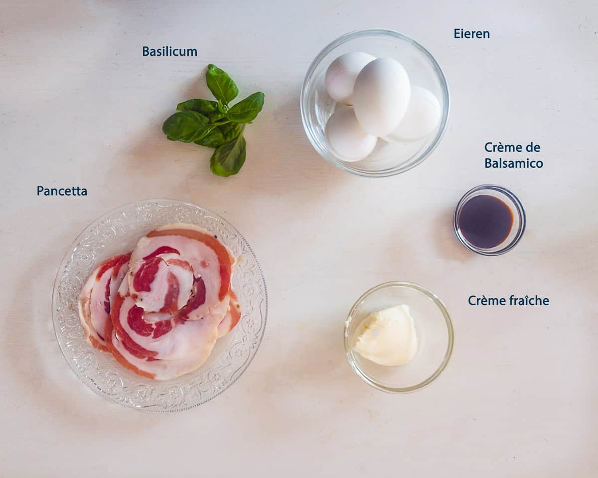 Ingredienten Italiaanse gevulde eieren met pancetta op een witte ondergrond met een tekstbeschrijving.