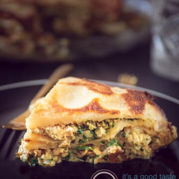 A slice of Pathiri on a black plate