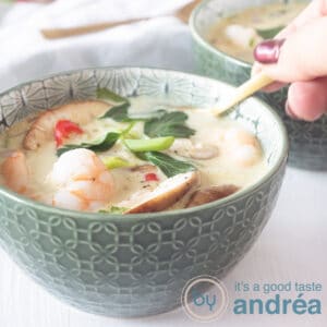 A square photo with a filled bowl with Thai coconut soup with shrimp.
