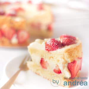 Square photo with a piece of chiffon cake with strawberries on a white plate. In the background the rest of the cake