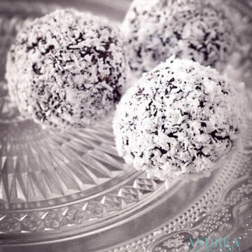 a glass plate with three coconut truffles