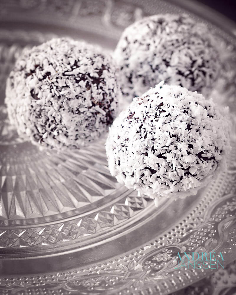a glass plate with three coconut truffles