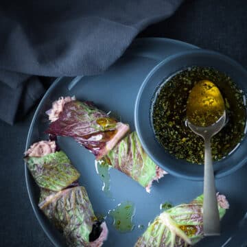 Lettuce wrap with tuna salad on a grey plate with a dressing