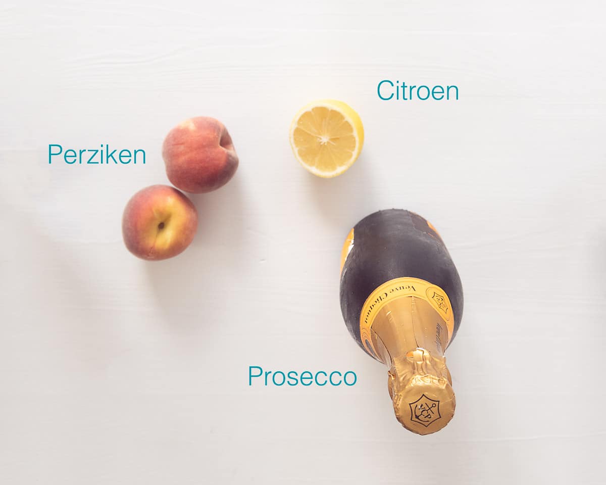 Ingrediënten Bellinic Cocktail Recept met Perzik Puree op een witte achtergrond met tekst erbij