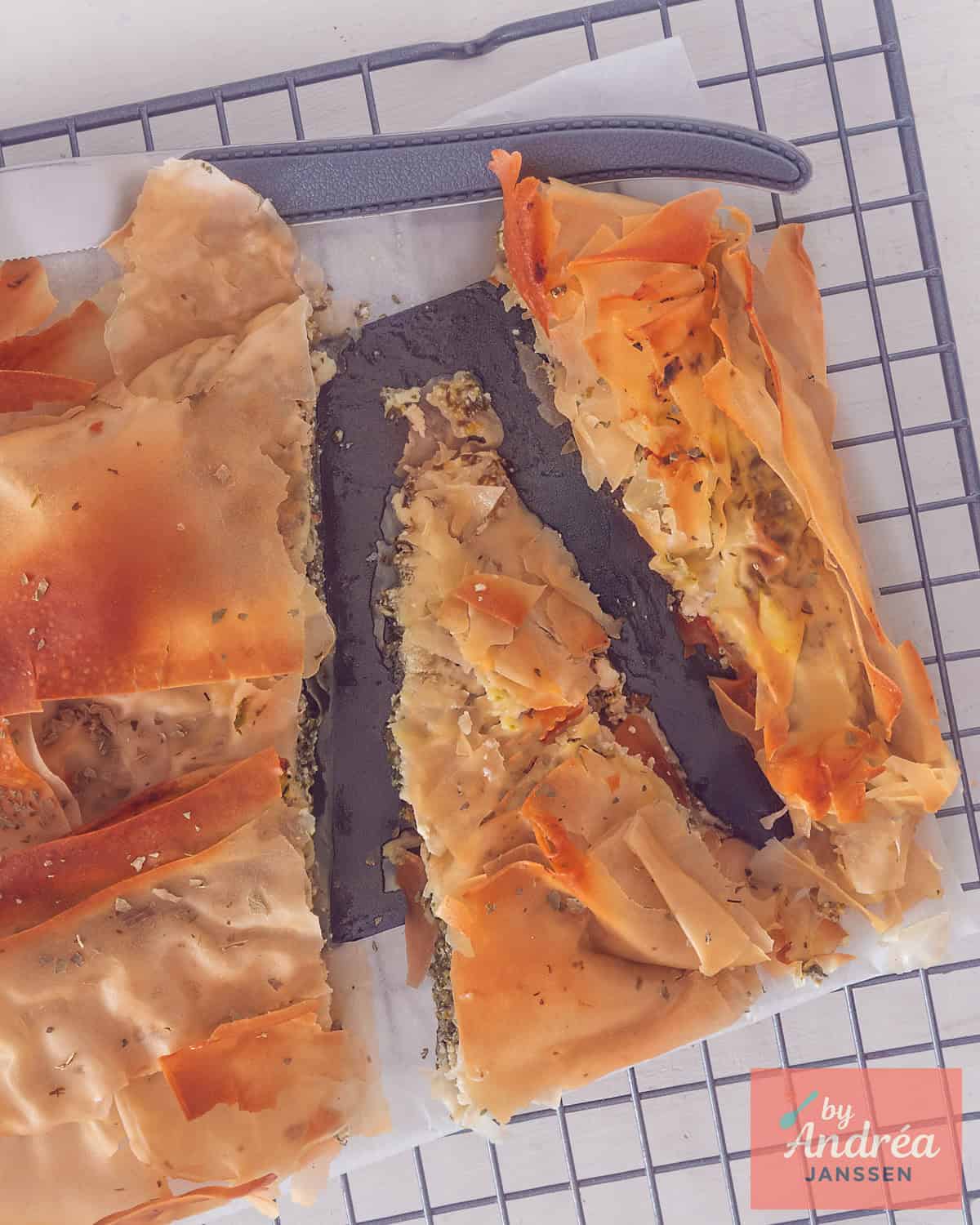 An overhead photo of a sliced ​​ricotta, spinach, and feta filo pastry cake.