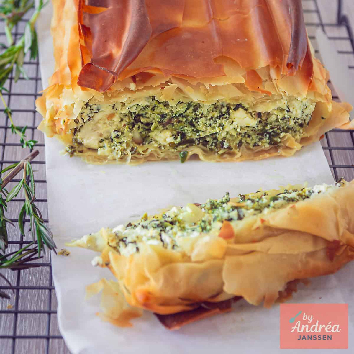 A square photo of a portion of a savory pie, clearly showing the filling (feta, spinach, and ricotta)