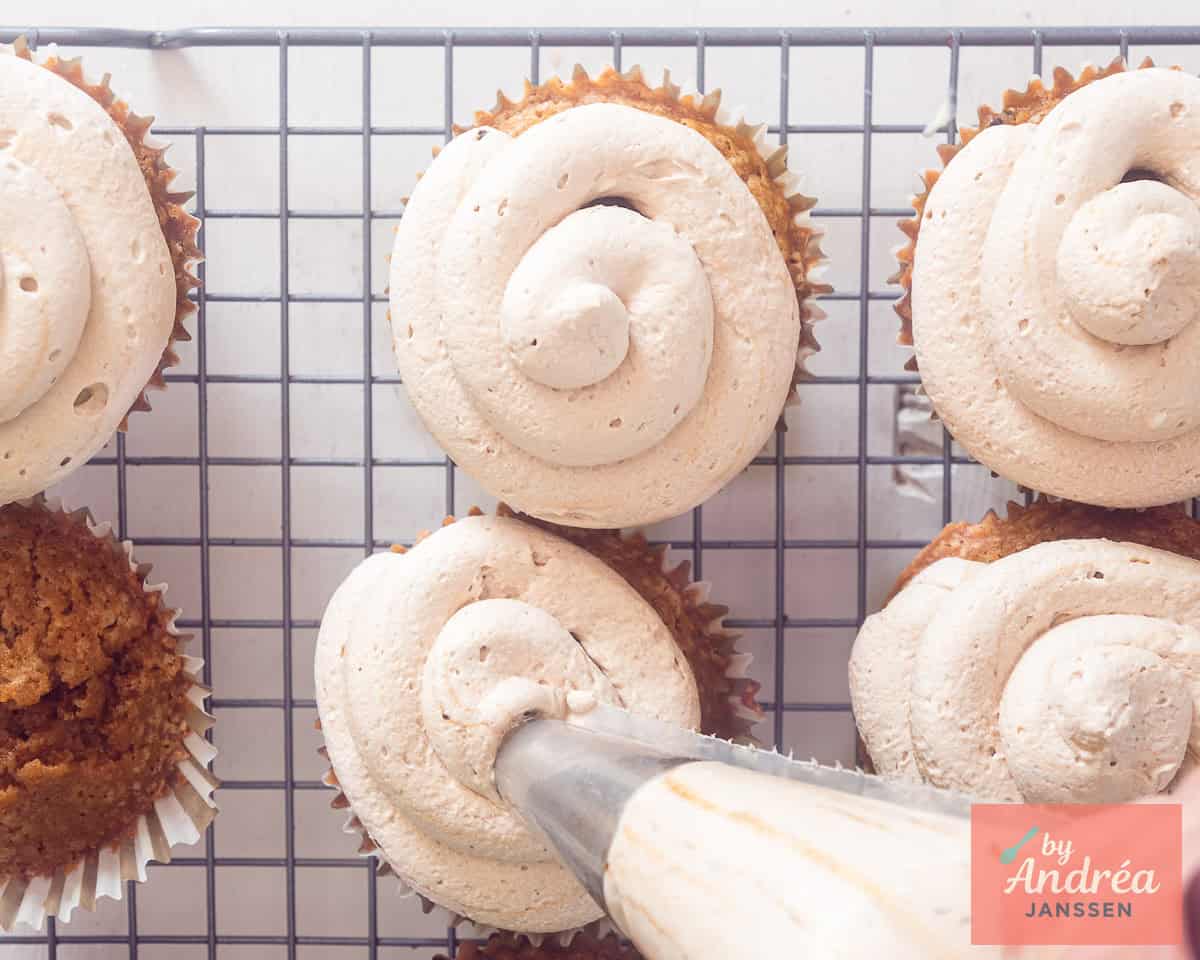 Piping frosting on cupcakes