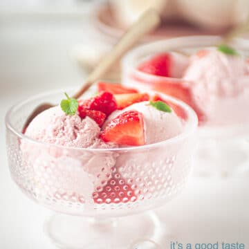 two glass bowls with strawberry ice cream with fresh strawberries and mint