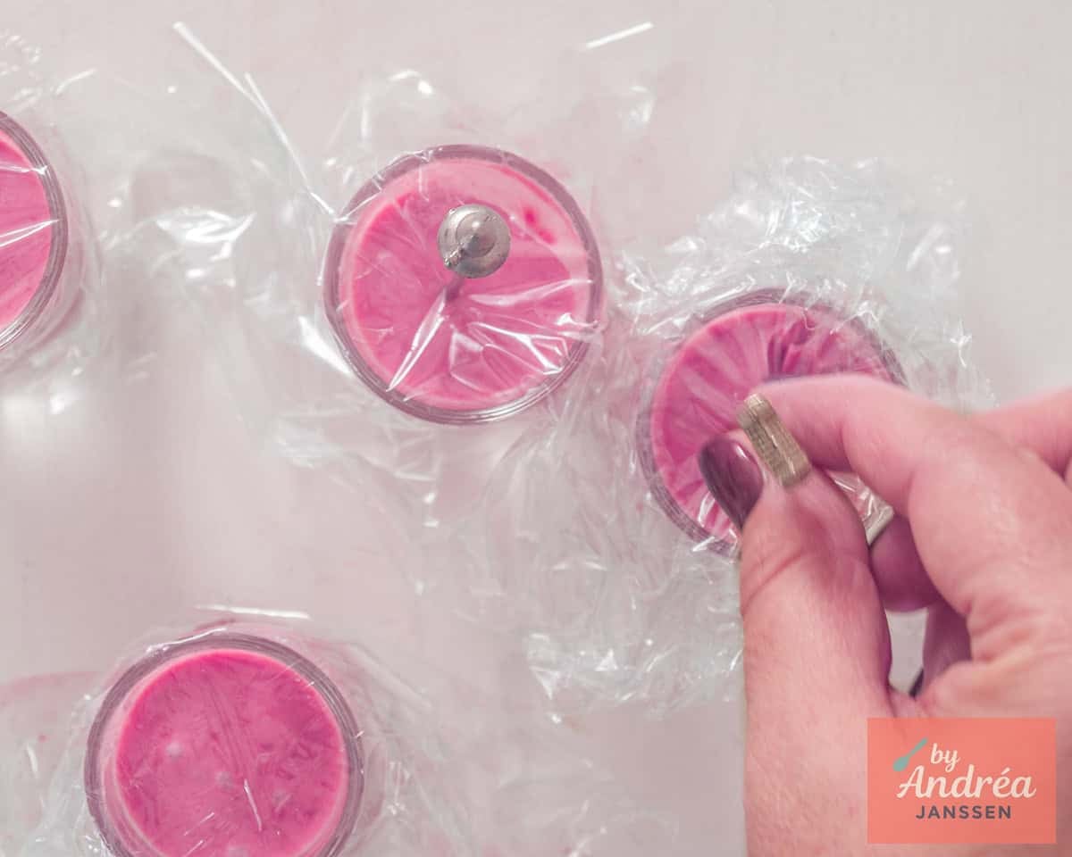 Het frambozenmengsel wordt in kleine glaasjes geschonken, er wordt een 'stokje' in gestoken en afgedekt met plastic
